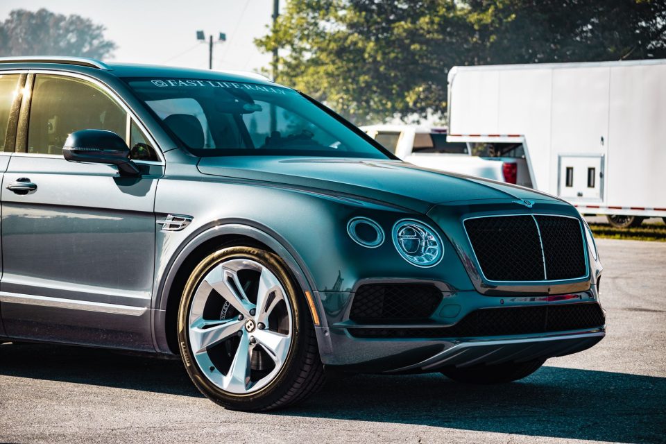 SUV Bentley estacionado em área urbana, com carroceria elegante e acabamento de luxo.