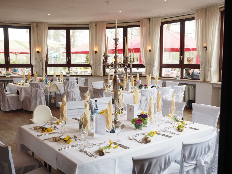 Sala de jantar elegante com mesas postas para um evento especial.